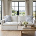 Blue and white seashell throw pillow styled in a beach house living room with natural accents