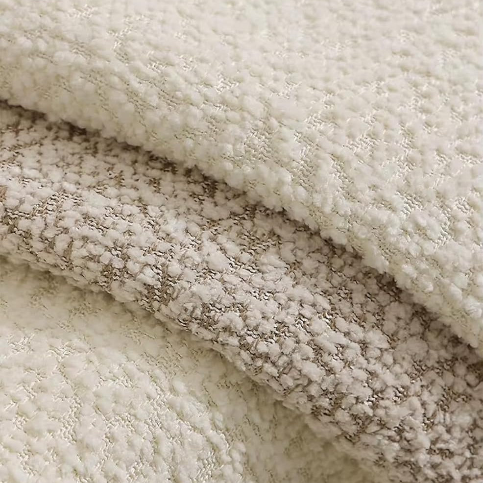 Plush brown bouclé lumbar pillow whose textured surface adds dimension to layered pillows.