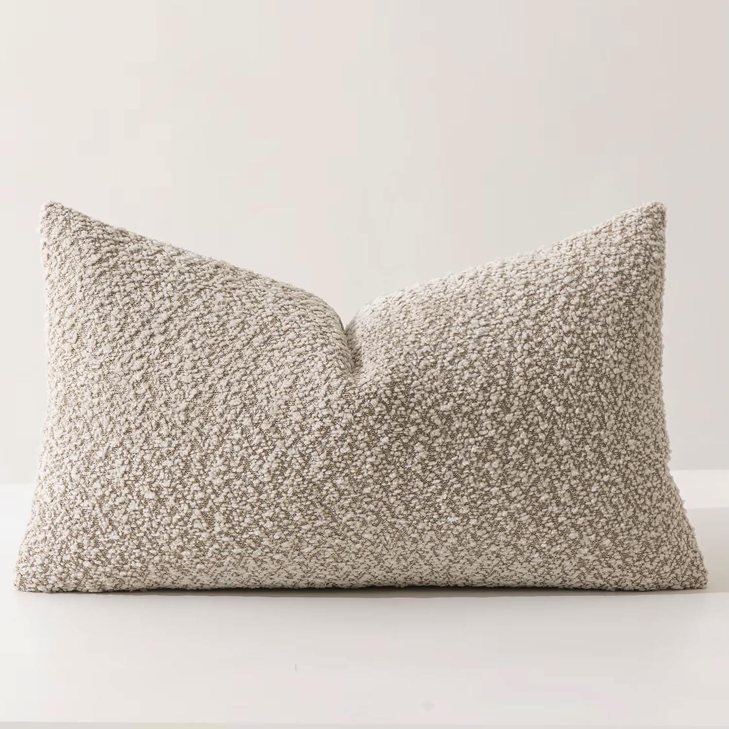 Rich brown bouclé throw pillow offering subtle luxury without overpowering surrounding decor.