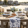 Chinoiserie blue and white floral table runner on a coastal dining table with white dishes.