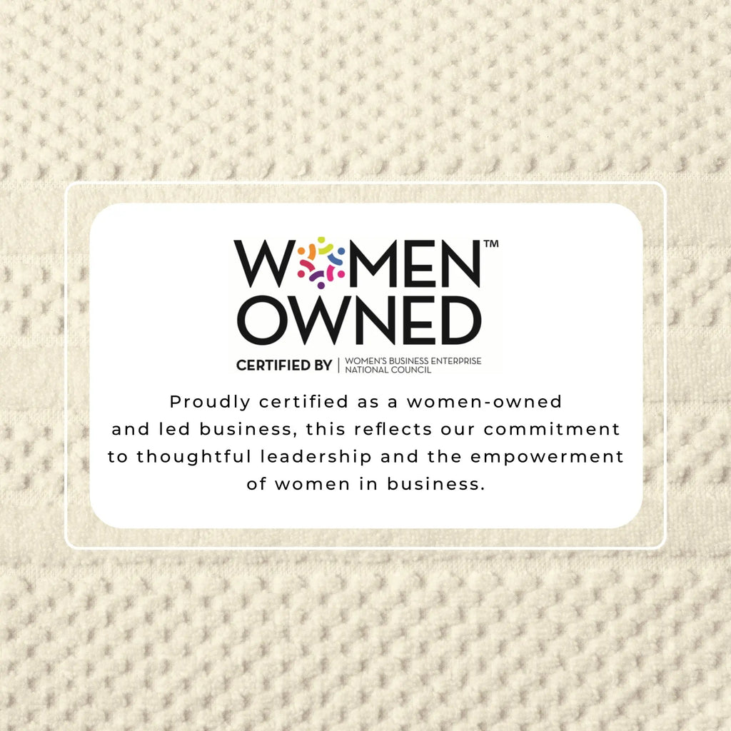 Bath towel set in 100% cotton checkered jacquard with a Women Owned certification badge on beige towel background.