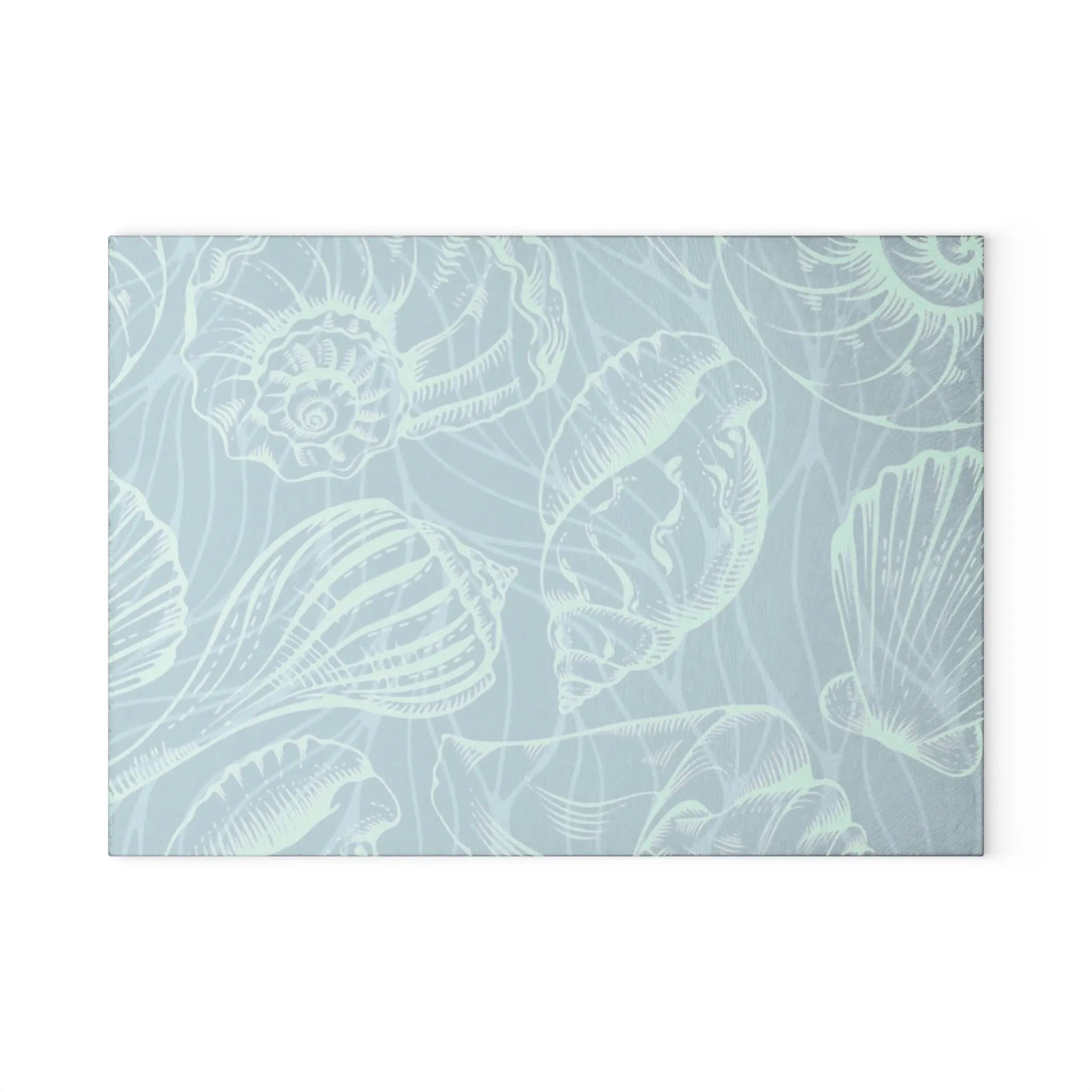 Tempered glass cutting board in seafoam tones with white seashell outlines.