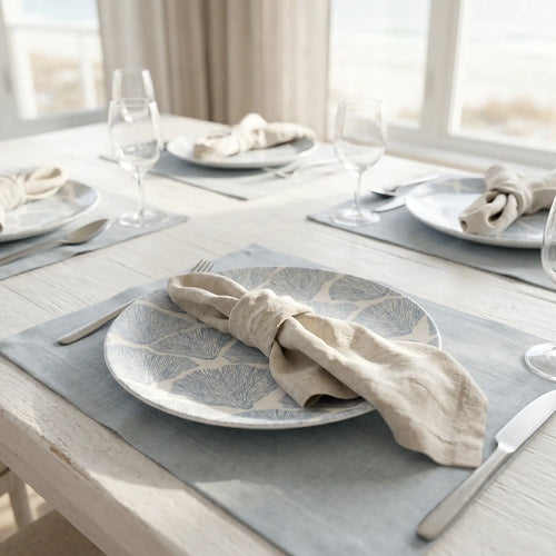 Blue coral dinner plates styled on a coastal table with neutral linens