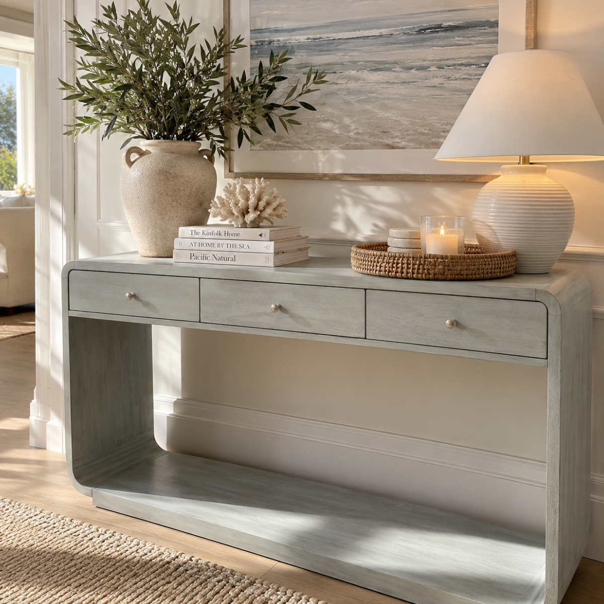 Three drawer coastal entryway console table with lower display shelf for hallway storage and decorative accents.