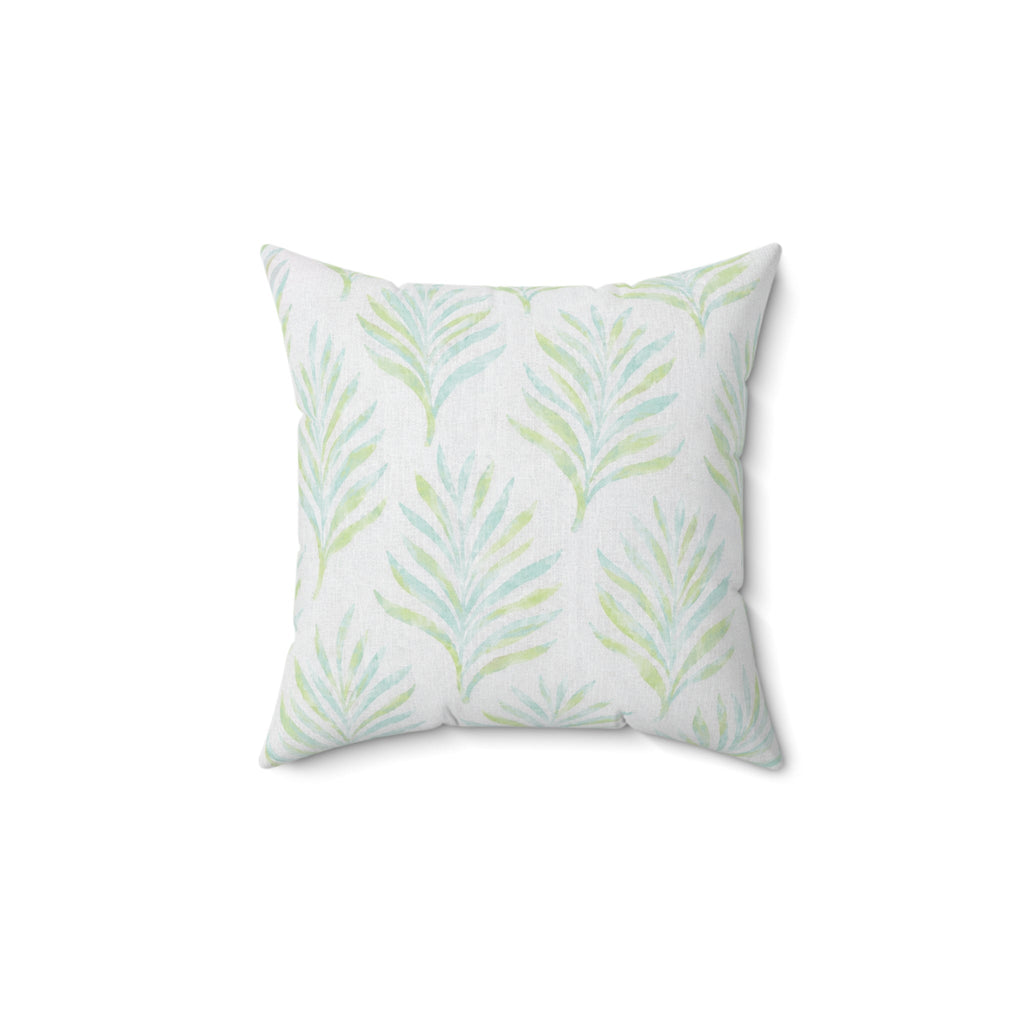 Coastal blue and green botanical pillow styled on a neutral sofa