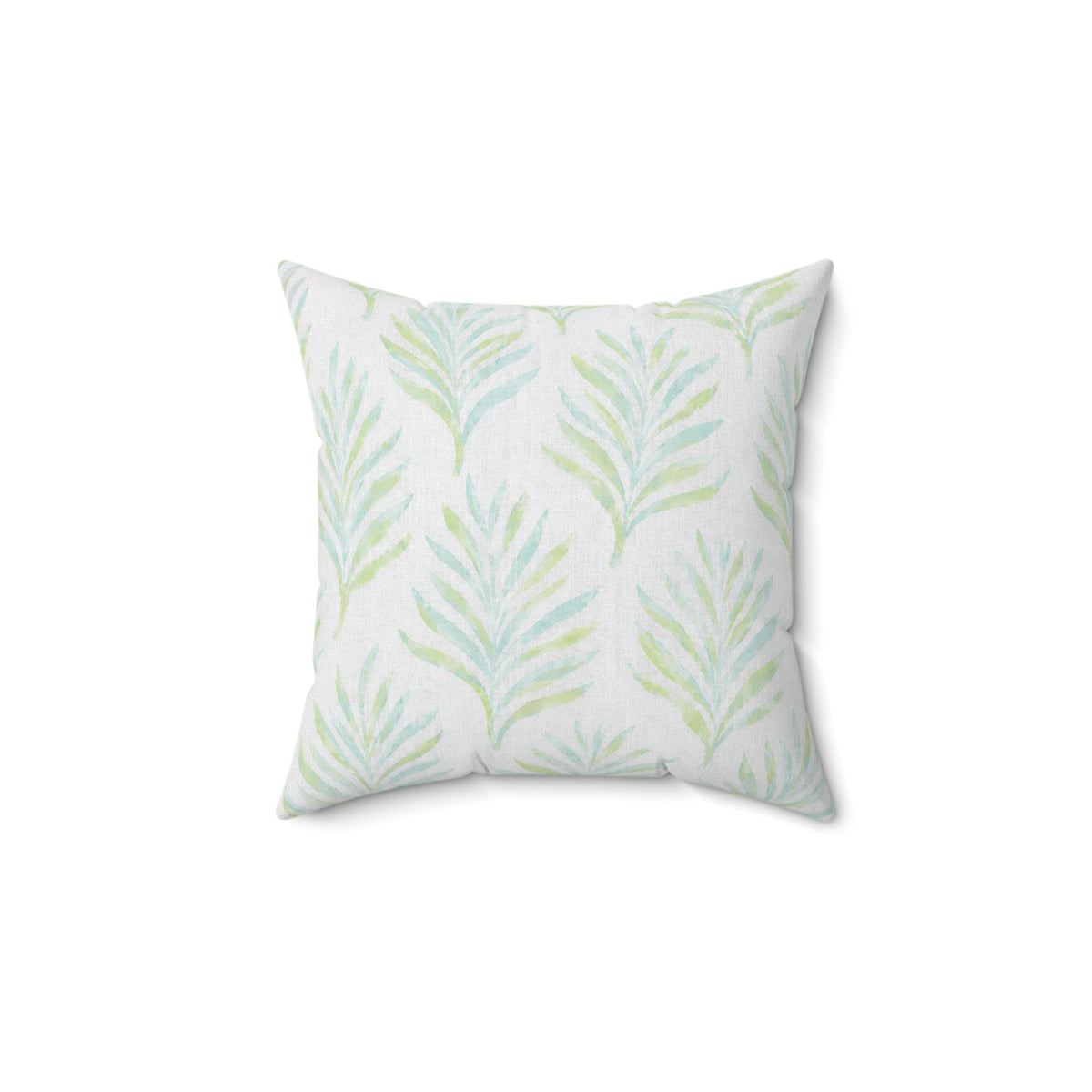 Coastal blue and green botanical pillow styled on a neutral sofa