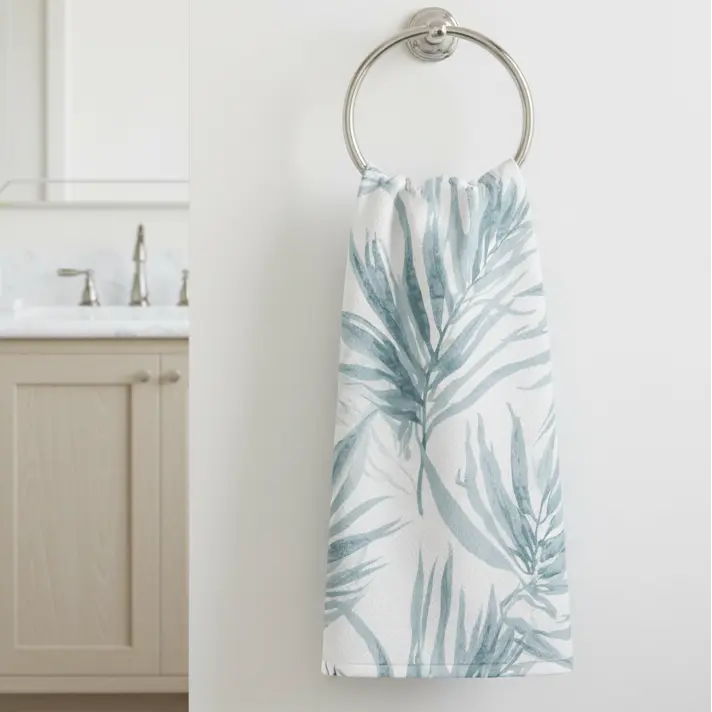 Blue palm face towel hanging on a hook in a beach-inspired bathroom.