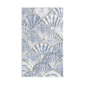 Towel with shell pattern hanging on a towel rack in a bathroom.