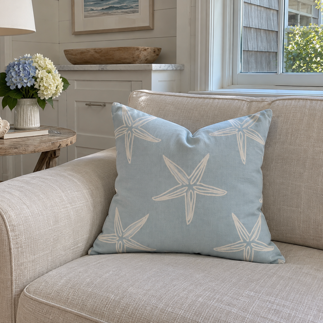 Coastal blue and white decorative pillow with a starfish print for a beach-inspired living room.