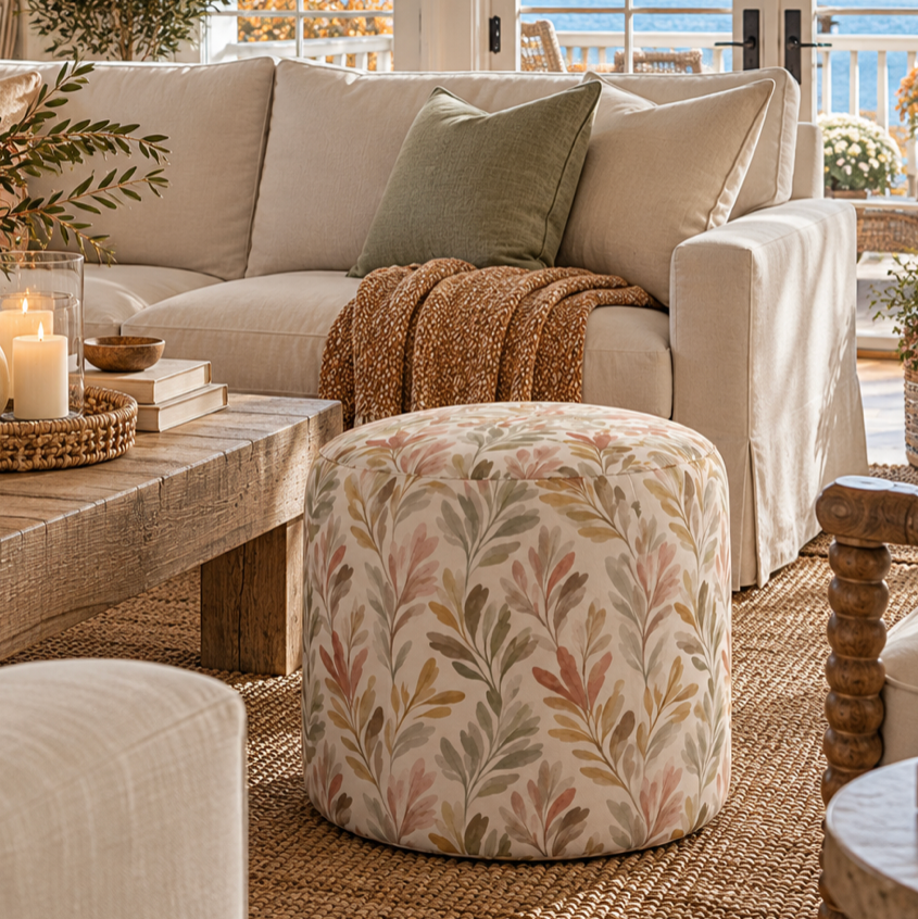 Coastal upholstered ottoman with a delicate botanical print in muted natural colors.