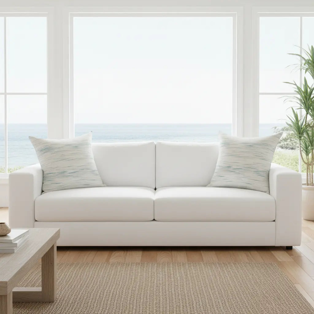 Coastal Breeze square pillow with blue watercolor stripe on white sofa.