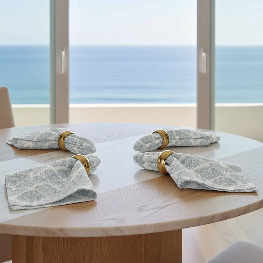 Bar Harbor Coral Linen Napkins – Set of 4 with blue seashell pattern on a coastal table.
