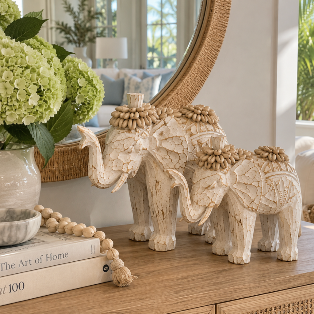 Ivory shell elephant figurines arranged on a shelf with natural textures and understated coastal decor.