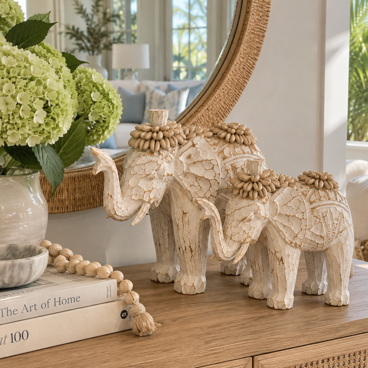 Ivory shell elephant figurines arranged on a shelf with natural textures and understated coastal decor.