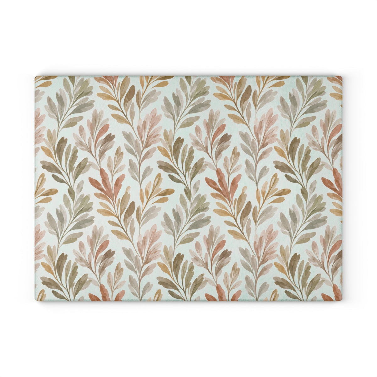 Decorative glass serving board with watercolor foliage print, placed on a white marble countertop