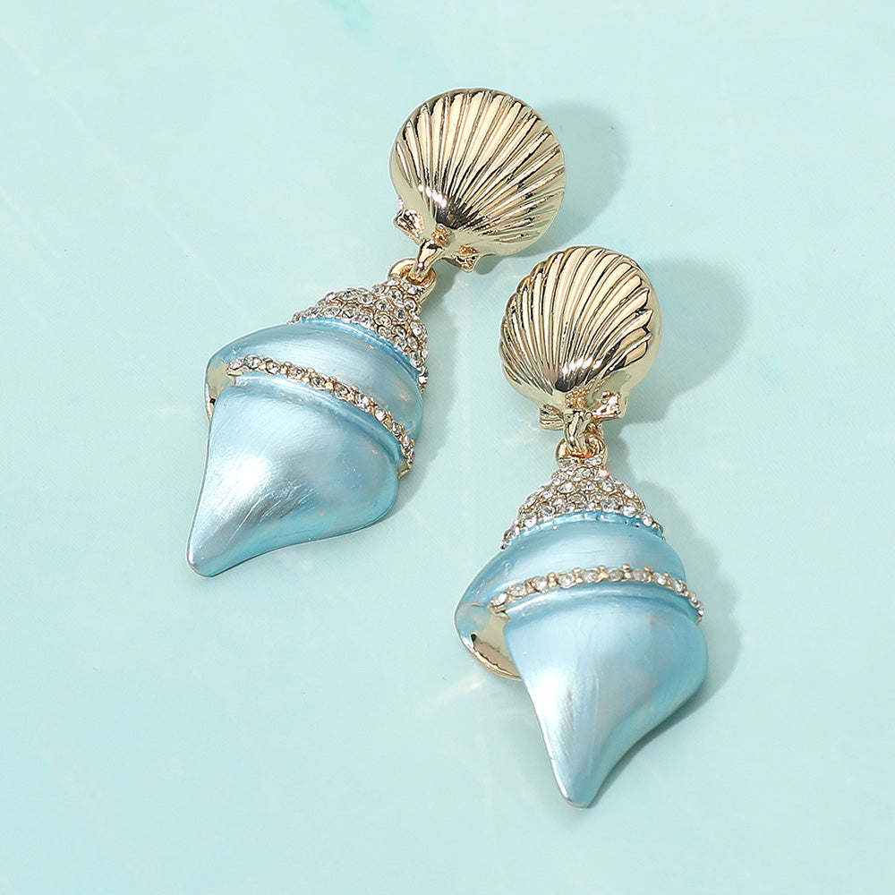 Coastal light blue gold dipped pearly conch shell stone pave earrings shown as beach inspired statement jewelry.