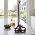 Octopus cast iron paper towel holder on coastal kitchen countertop with nautical dishware