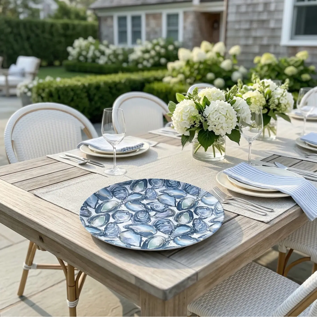 Oyster Serving Tray with a blue shell pattern on an outdoor dining table, surrounded by white hydrangea centerpieces.