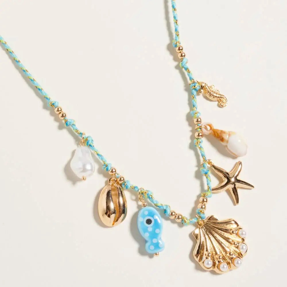 Coastal pearl necklace with seashell, starfish and seahorse charms on a twisted fabric chain.