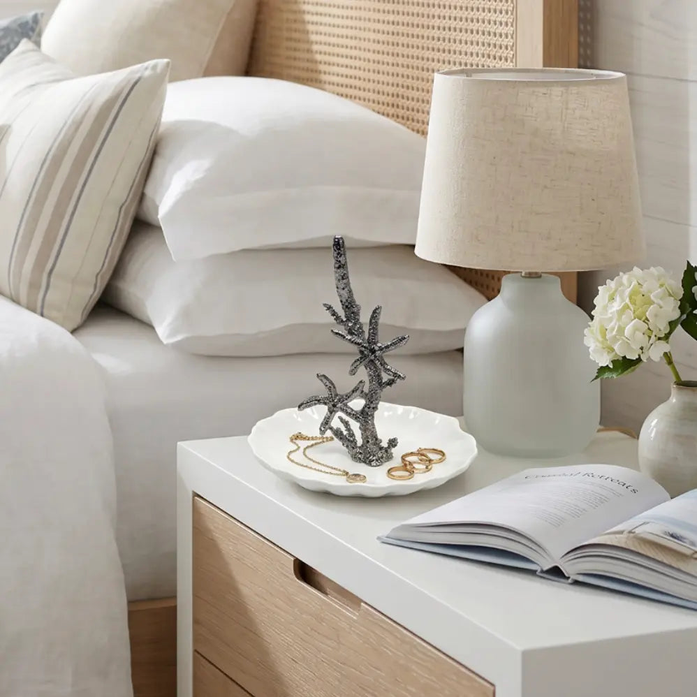 Starfish ring holder placed on a bedside table in a seaside-inspired room