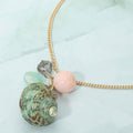 Coastal seashell and pebble charm necklace shown as beach inspired everyday jewelry