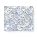 Blue and white seashell comforter adding a nautical pattern to a bright seaside bedroom