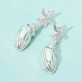 Silver dipped starfish seashell drop earrings displayed on an earring card for beachy summer outfits