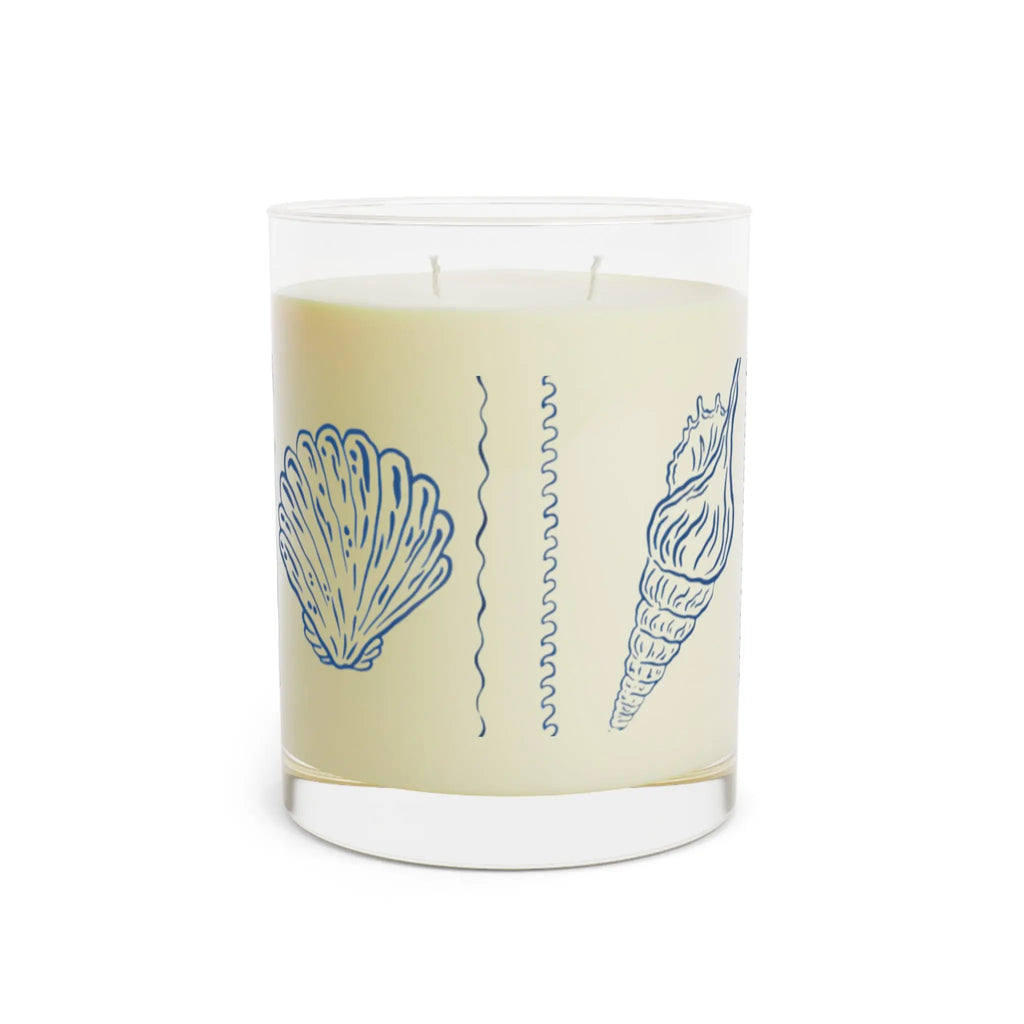 Seashell Reverie Ocean Mist Candle. Coastal blue seashell sketch on cream candle in clear glass holder.