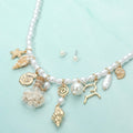 Starfish and shell charm station beaded pearl coastal necklace shown as beach inspired jewelry.