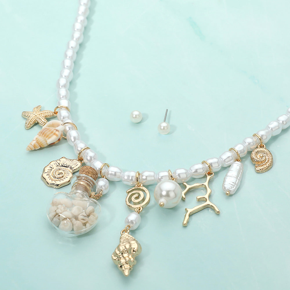 Starfish and shell charm station beaded pearl coastal necklace shown as beach inspired jewelry.
