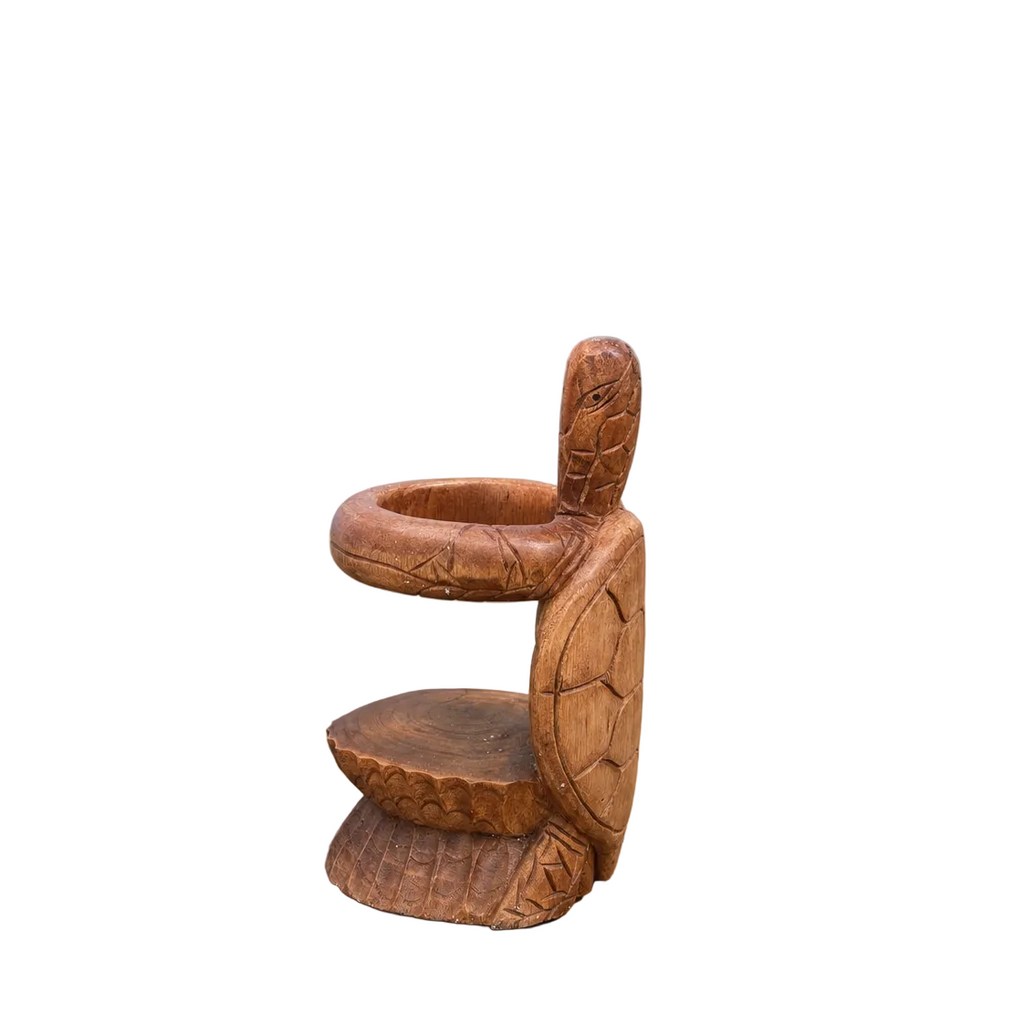 Wooden turtle wine bottle holder styled on a light countertop in a luxury coastal-inspired home.