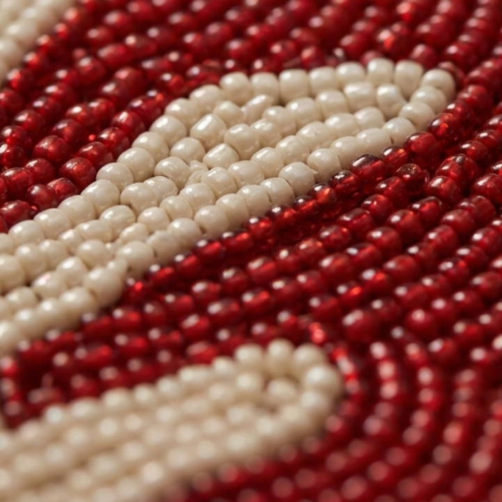 Beaded placemat featuring an elegant red coral-inspired design.