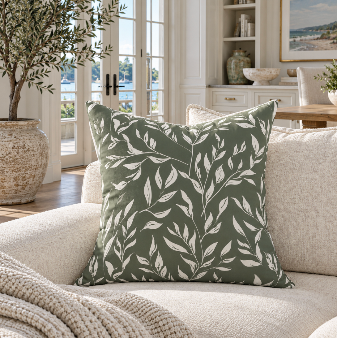 Dark green decorative pillow featuring a classic white floral pattern.