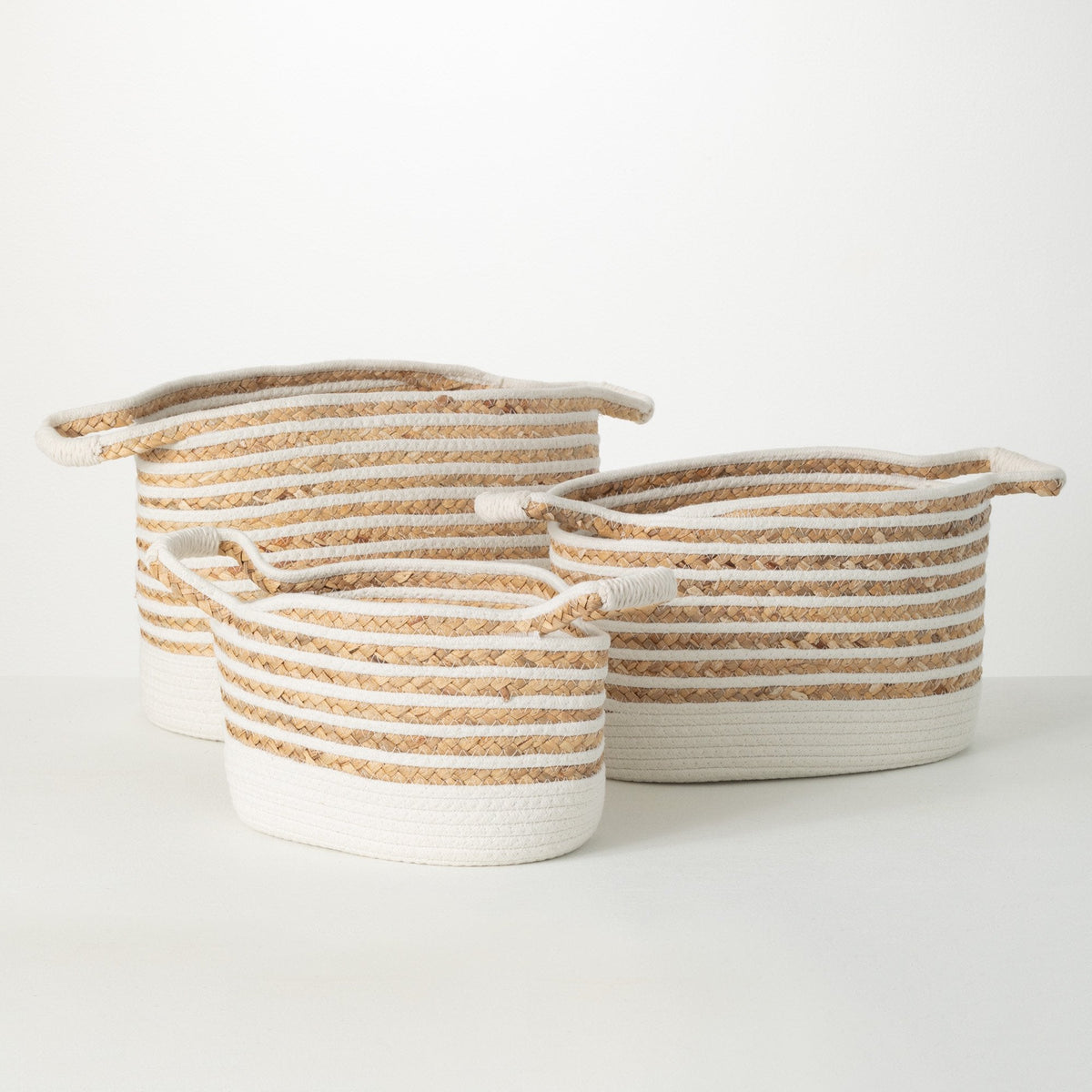 Large woven rope storage basket filled with a neutral knit throw beside a coastal-style sofa.