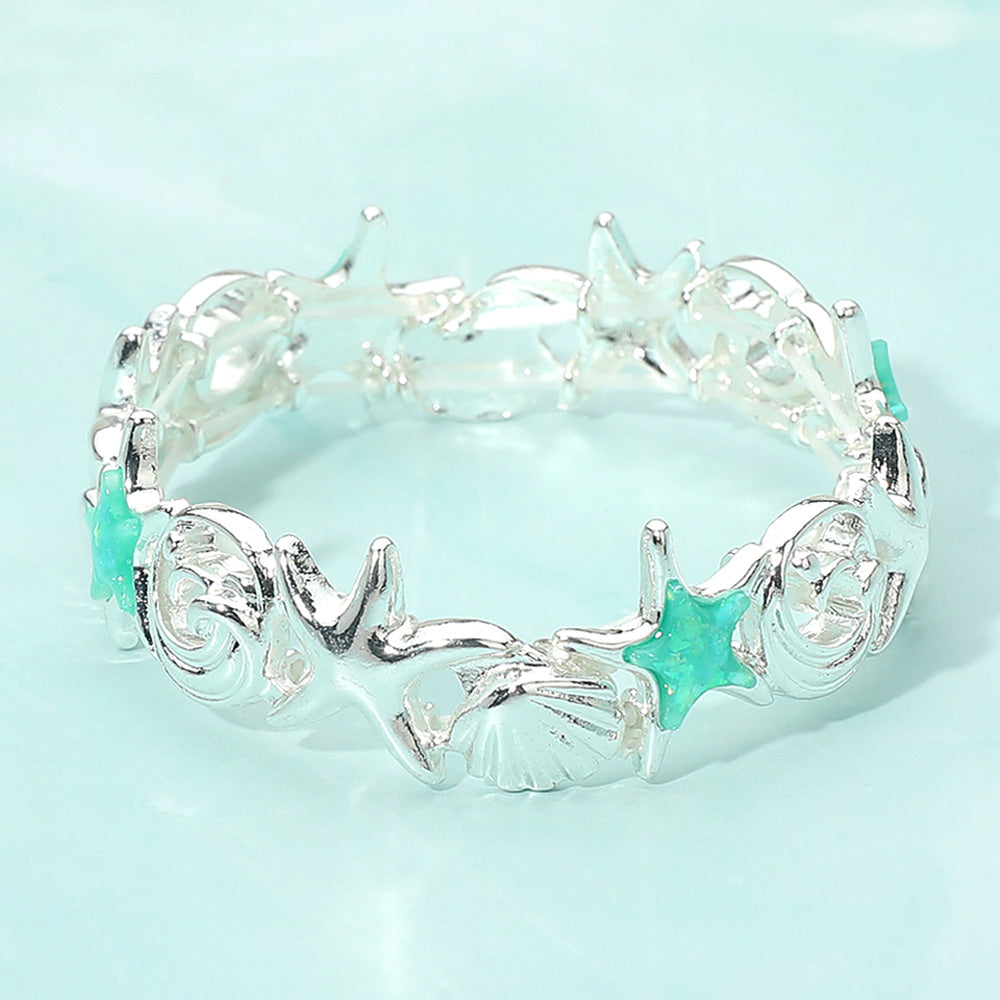 Coastal wave link starfish and shell stretch bracelet photographed in a flatlay with seashells