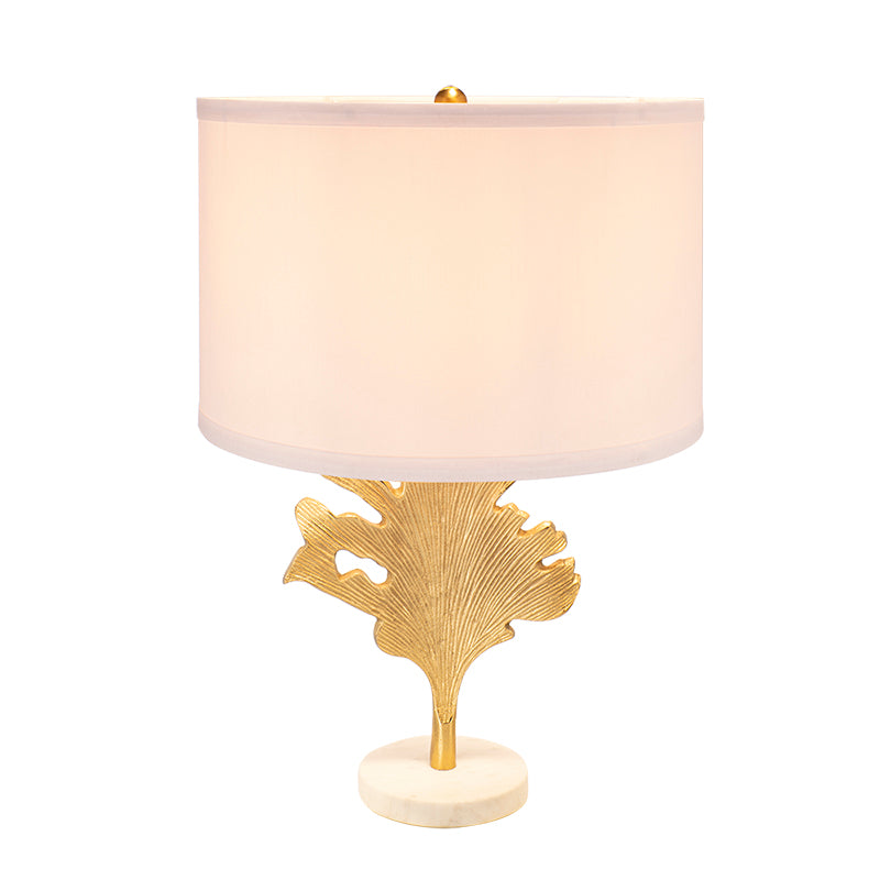 Designer-inspired gold table lamp displayed on a natural wood living room side table.