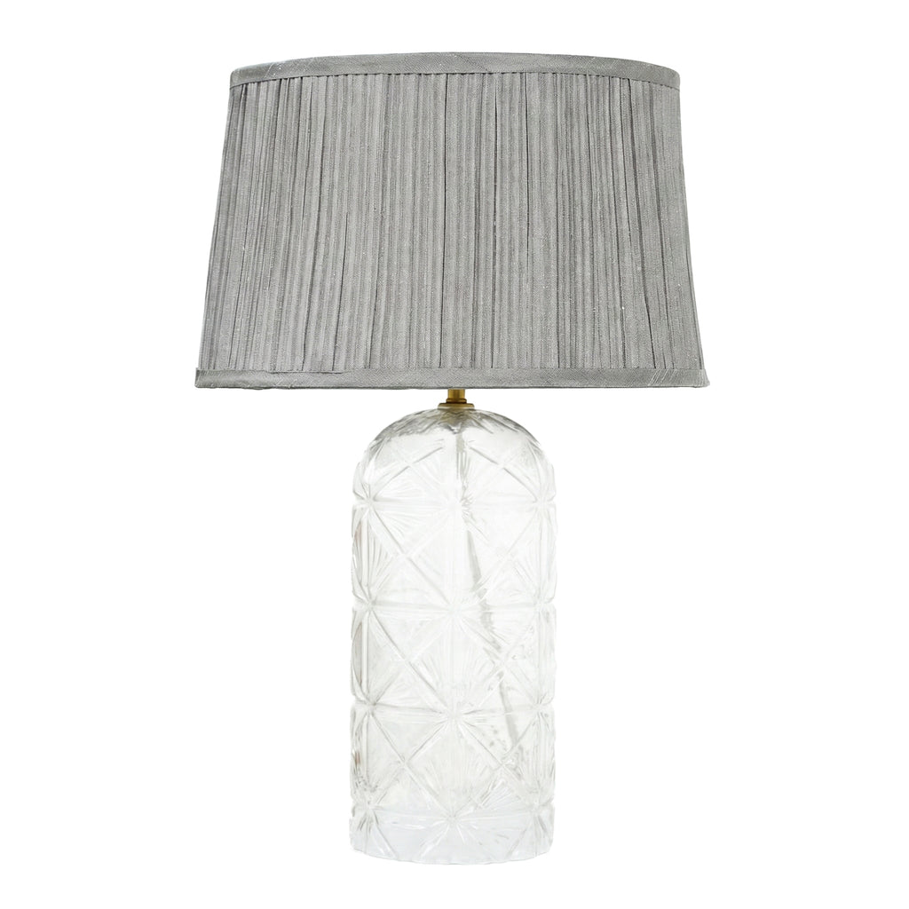 Luxury decorative lamp with a clear glass body and pleated grey shade for elegant home decor.