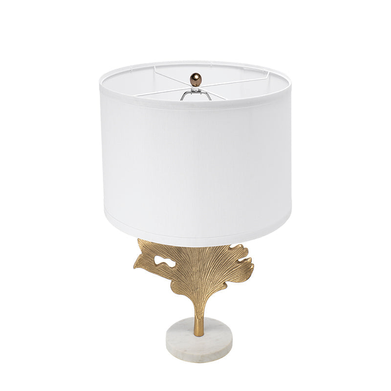 Gold leaf table lamp adding elegant accent lighting to a coastal-inspired bedroom.