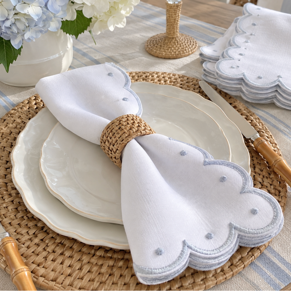 Embroidered scallop dinner napkins with decorative stitched detailing.