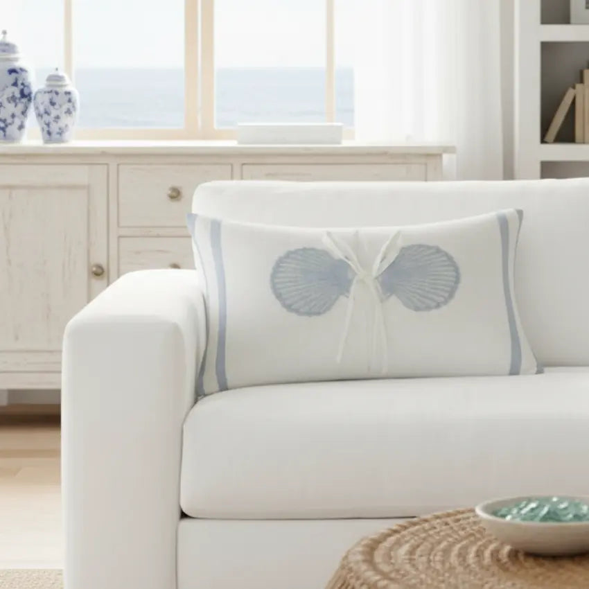 Coastal Seashell Decorative Lumbar Pillow, 12x20, white with blue seashell motif and tied bow on a sofa.