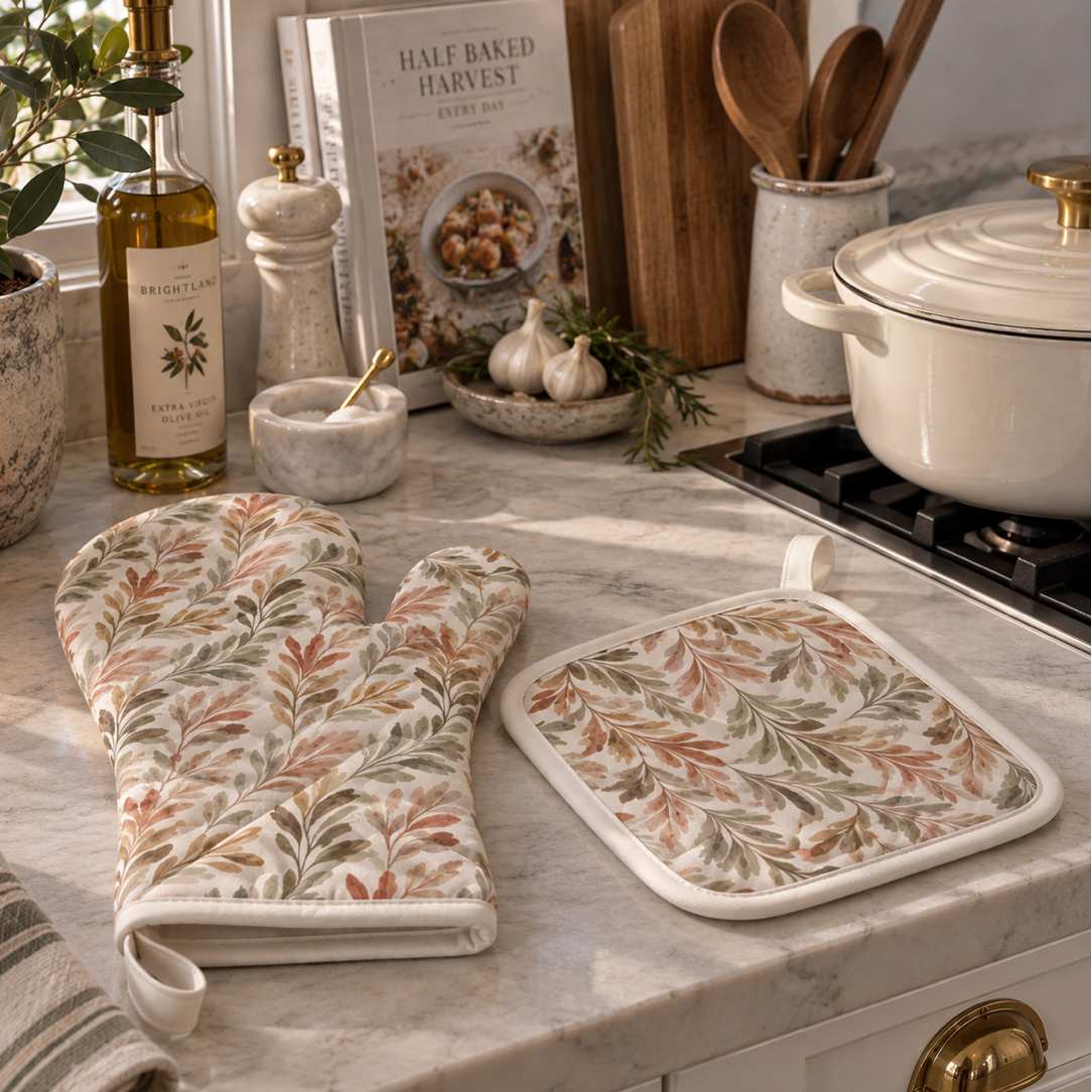 Two-piece cotton kitchen set featuring a nature-inspired leaf print, oven mitt and trivet-style pot holder