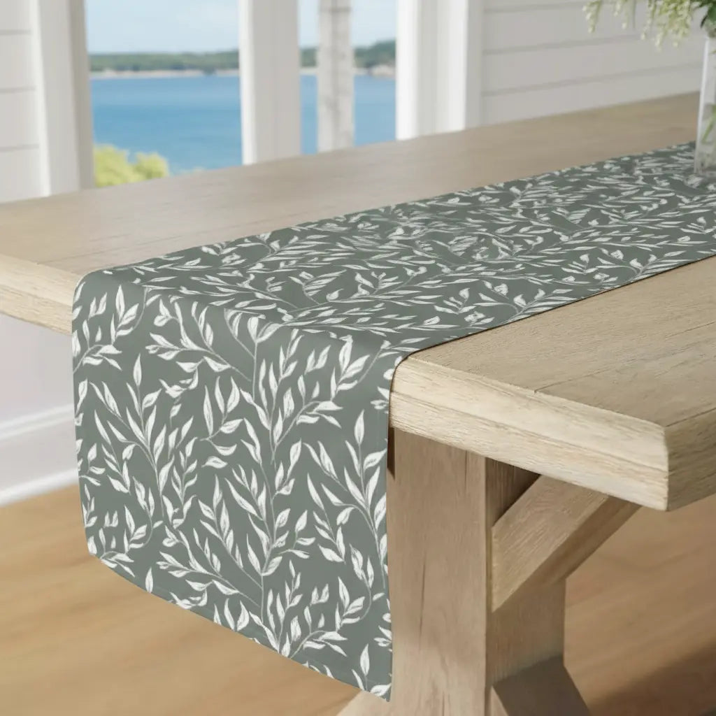 Green and white floral table runner on a dining table with simple place settings