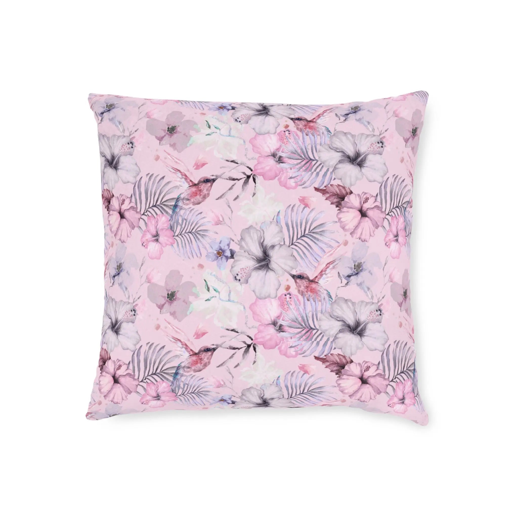 Pink floral throw pillow with hummingbirds and tropical flowers in soft pastel tones.