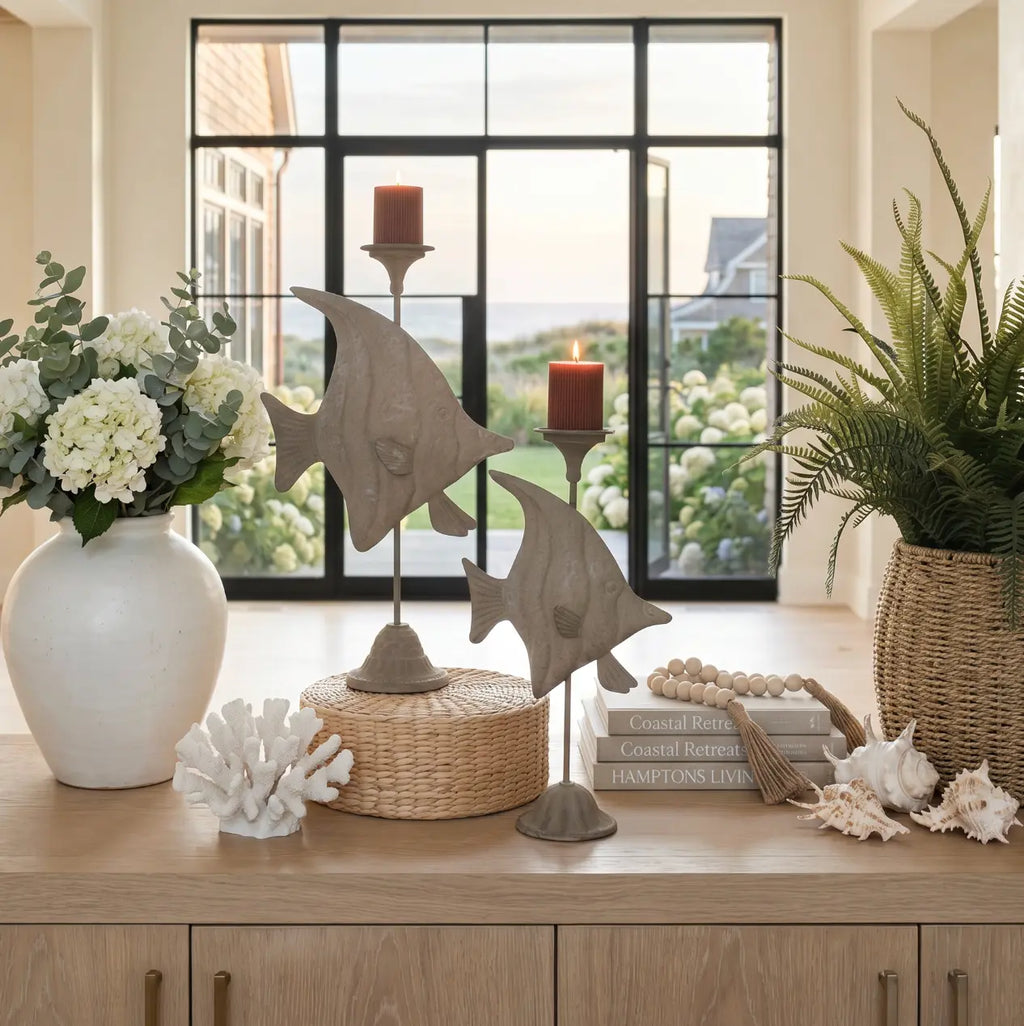 Set of two fish candle holders styled as coastal decor on a living room table.