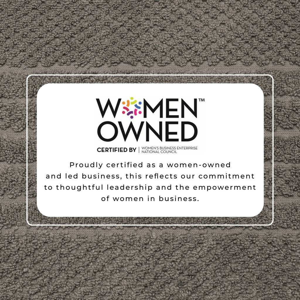 Great Bay Home bath towel showing Women-Owned certification label on brown textured jacquard fabric.