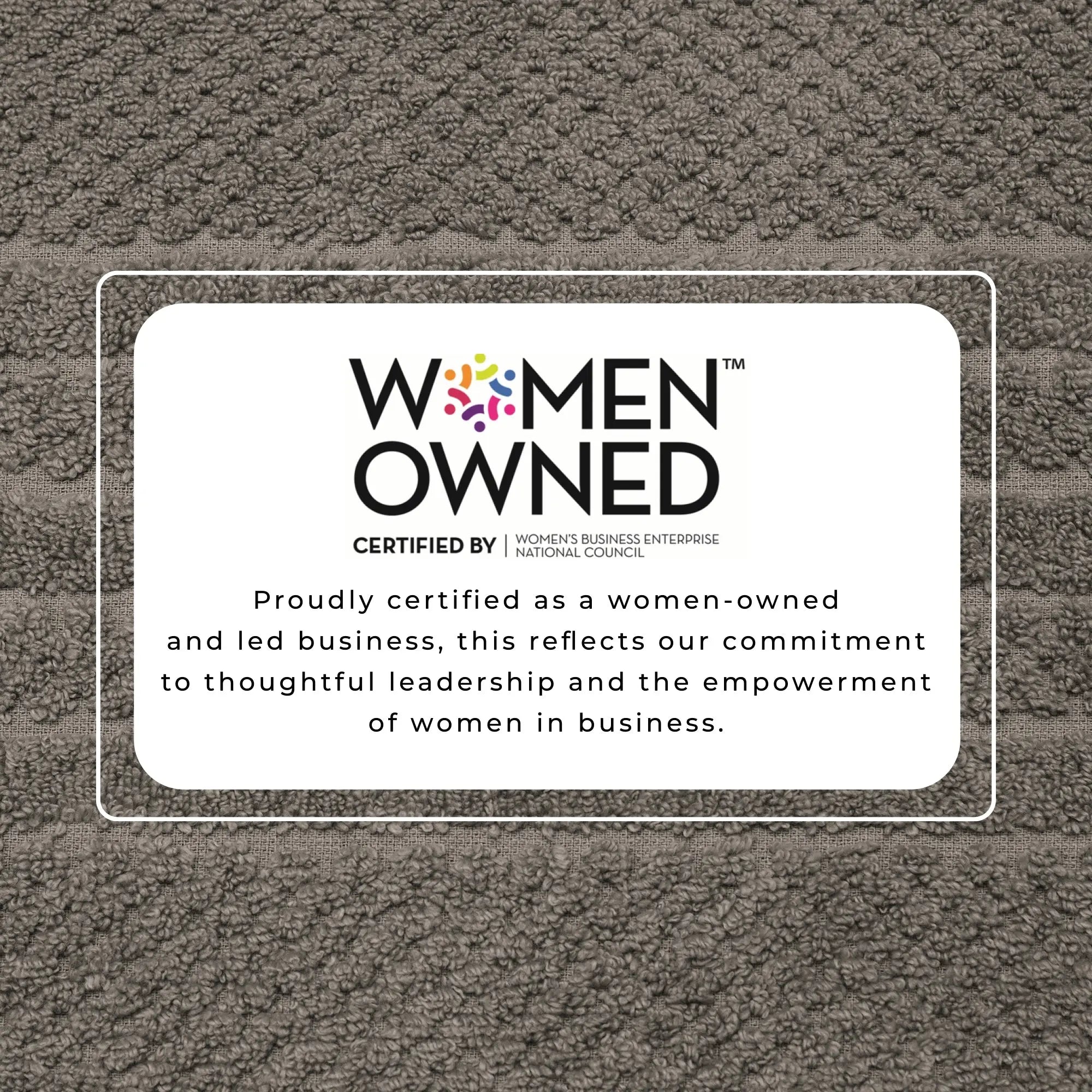 Bath towel with Women-Owned certification label on brown terry fabric