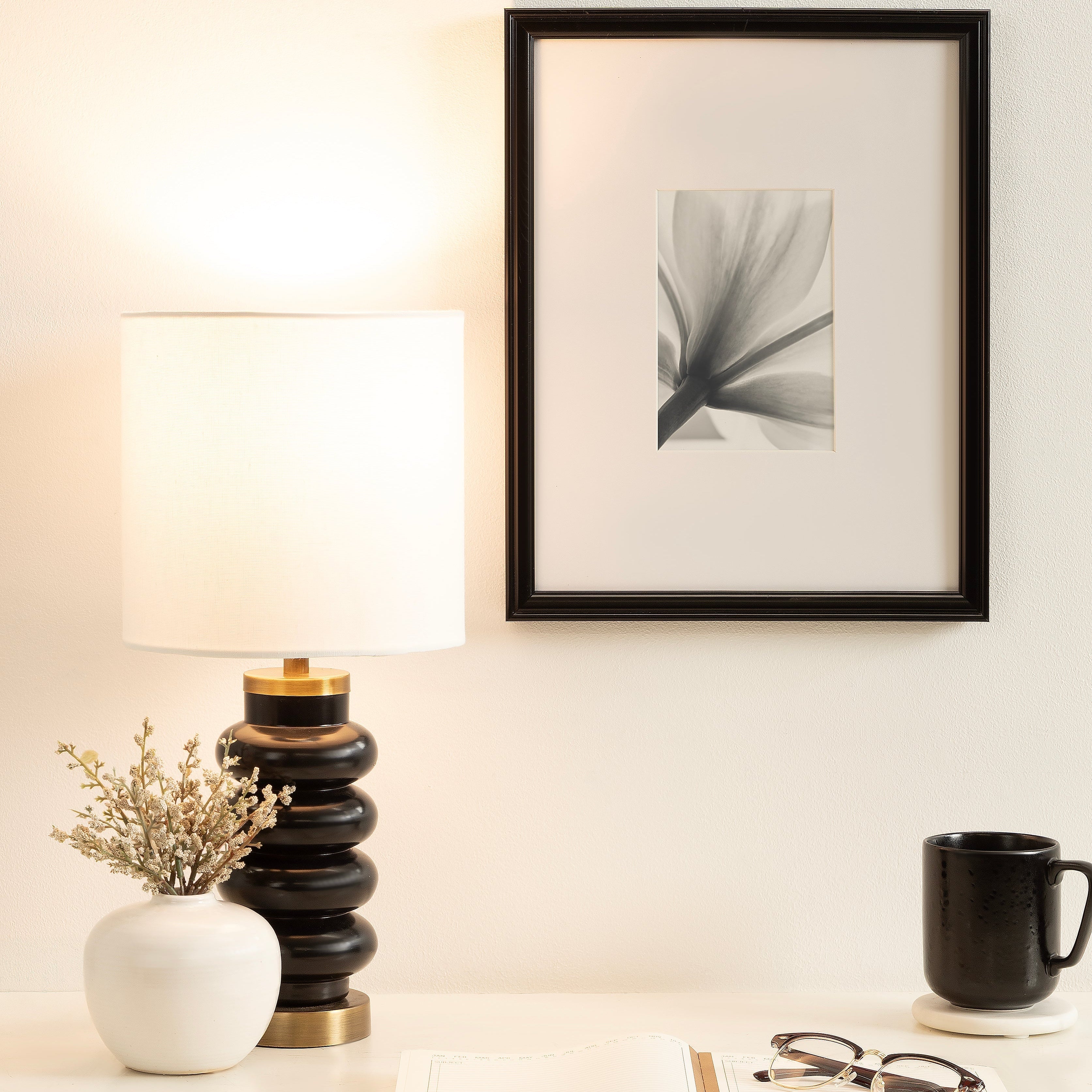 Sculptural black table lamp featuring a bubble‑style ceramic base and crisp white fabric shade.