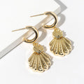 Coastal gold dipped textured scallop shell dangle mini hoop earrings shown as beach inspired jewelry.