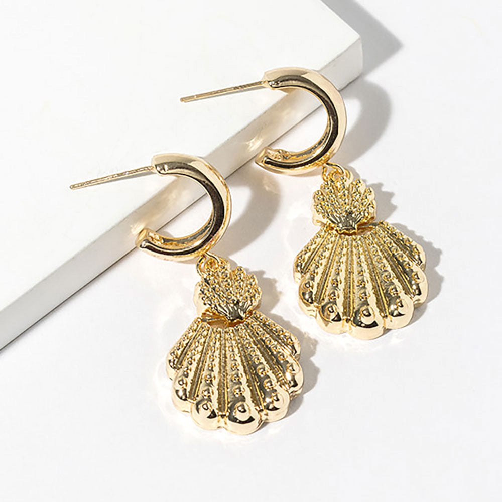 Coastal gold dipped textured scallop shell dangle mini hoop earrings shown as beach inspired jewelry.