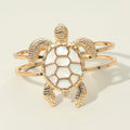 Gold turtle hinged bracelet featuring a mother of pearl shell detail worn in a beach inspired outfit.